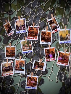 Polaroids of members pinned to a net on the club wall
